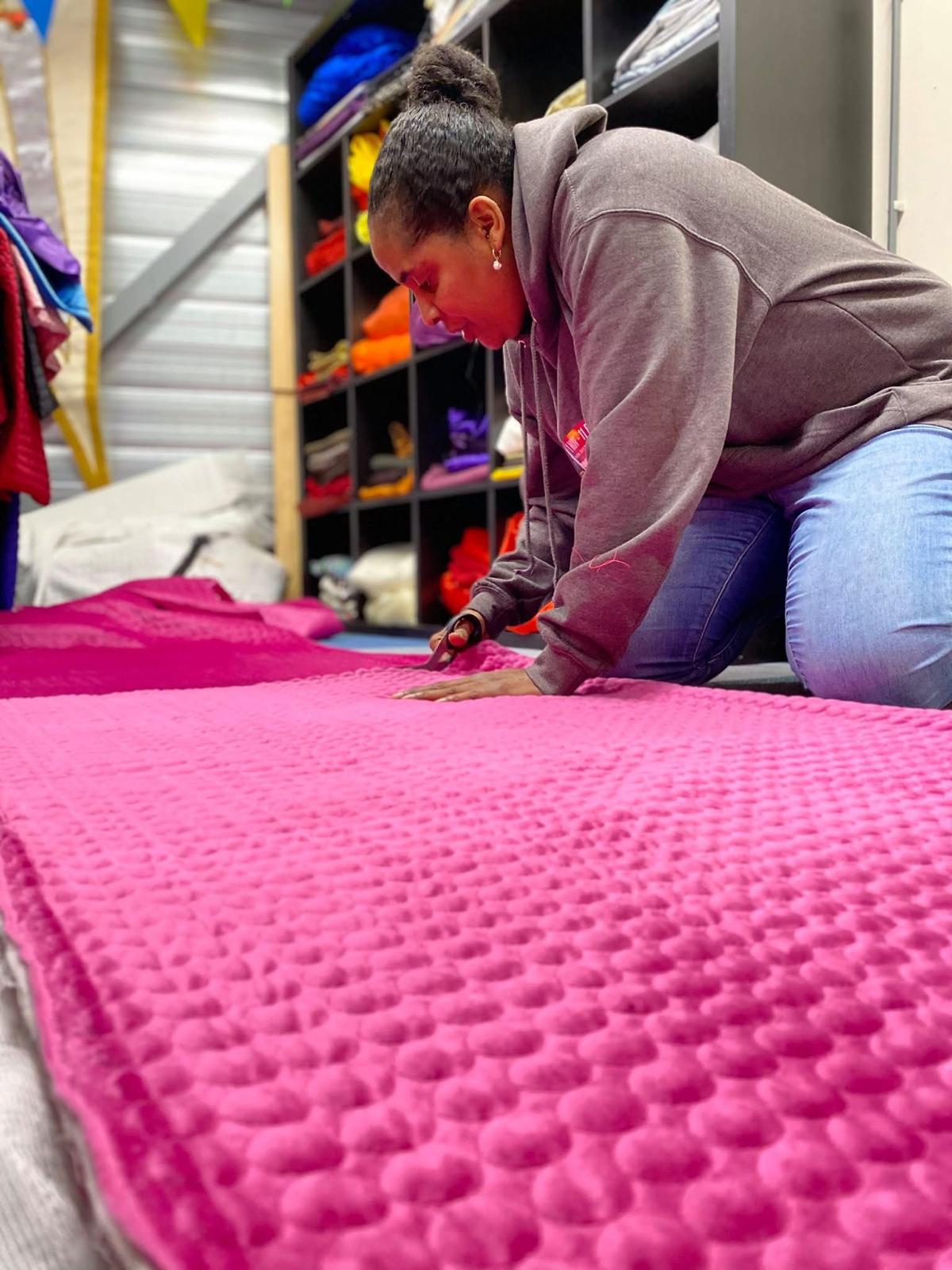 Trevalcha strijkt fuchsia stof glad in het atelier